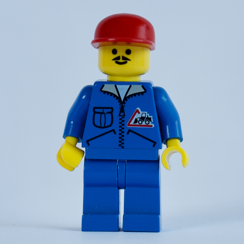 Travailleur de la construction, veste bleue avec fermeture à glissière et badge bulldozer, jambes bleues, casquette rouge, moustache (Construction Worker, Blue Jacket with Zipper and Bulldozer Badge, Blue Legs, Red Cap, Moustache)