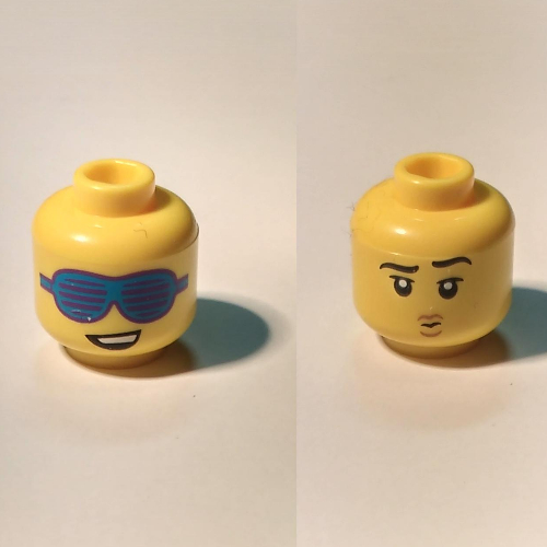 Tête de minifigurine, Double face, sourire lopside et grandes lunettes de soleil bleues à fentes / sourcils surélevés et petite bouche de poussage (Minifig Head, Dual Sided, Lopsided Smile and Large Slotted Blue Sunglasses / Raised Eyebrow, and Small Pouting Mouth)
