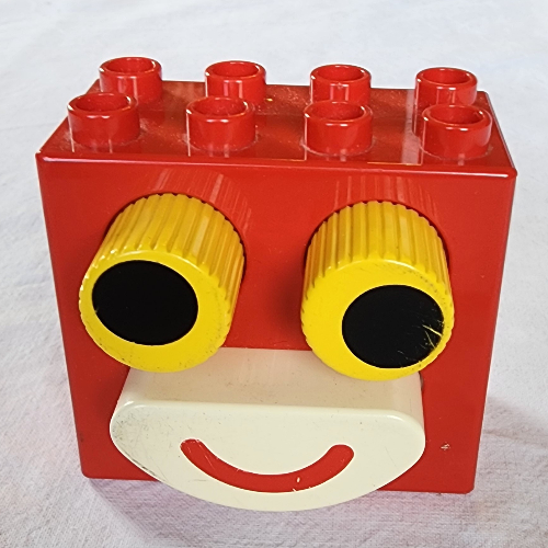 Visuel indicatif Rebrickable de Duplo brique 2 x 4 x 2 avec yeux jaunes noirs et bouche blanche (Duplo Brick 2 x 4 x 2 with Black in Yellow Eyes and White Mouth)